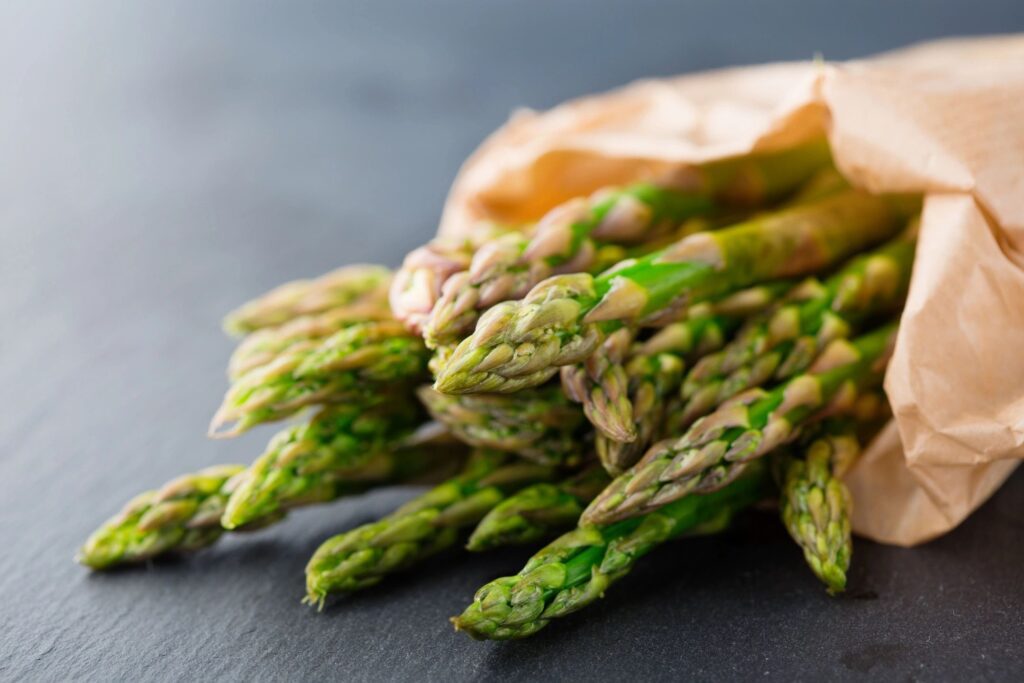 A bunch of asparagus in a brown paper bag